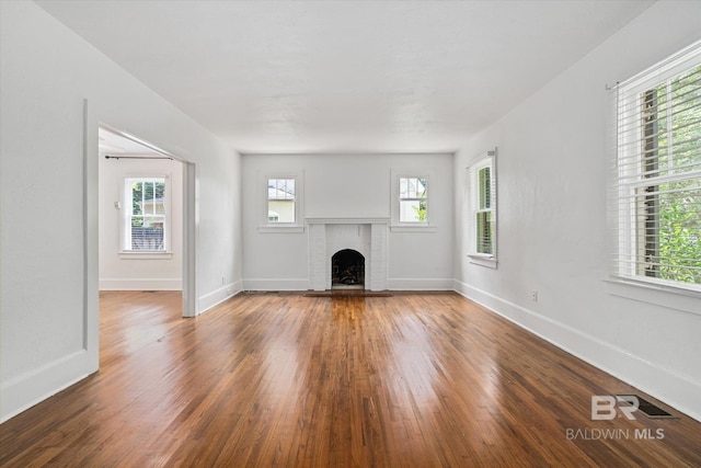 unfurnished living room featuring dark wood-type flooring and a fireplace