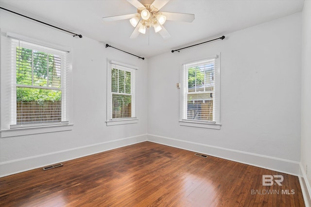 spare room featuring ceiling fan, hardwood / wood-style floors, and a wealth of natural light