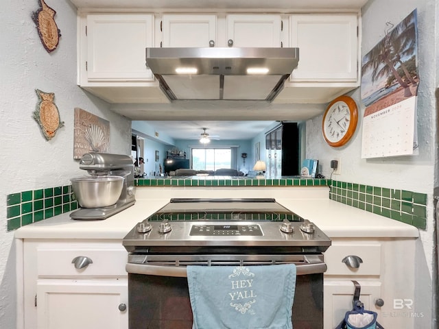 kitchen featuring extractor fan, ceiling fan, white cabinets, decorative backsplash, and electric range