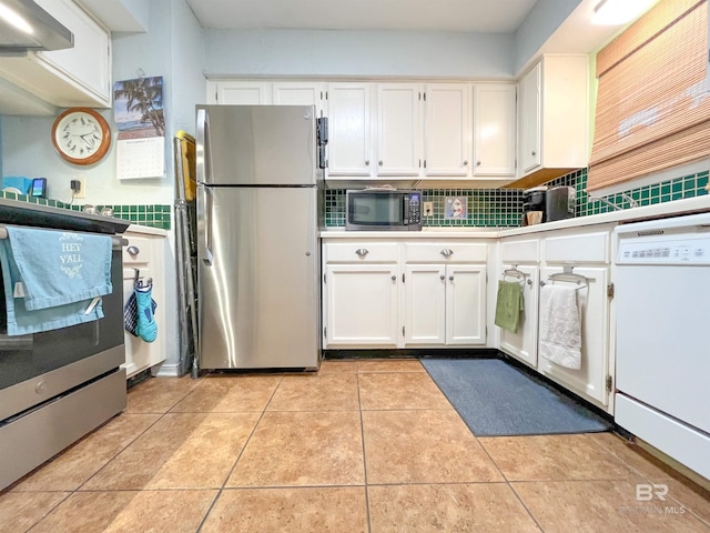 kitchen featuring white cabinets, decorative backsplash, wall chimney exhaust hood, light tile patterned floors, and appliances with stainless steel finishes