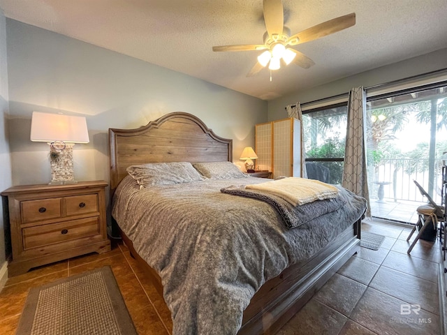 bedroom featuring access to outside, a textured ceiling, and ceiling fan