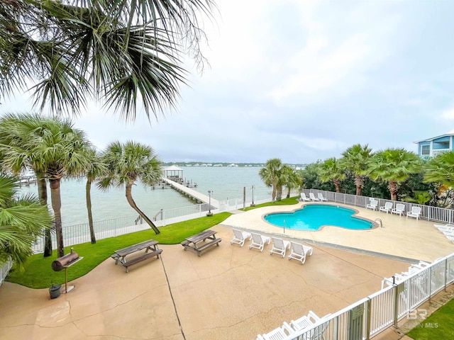 view of swimming pool with a water view and a patio