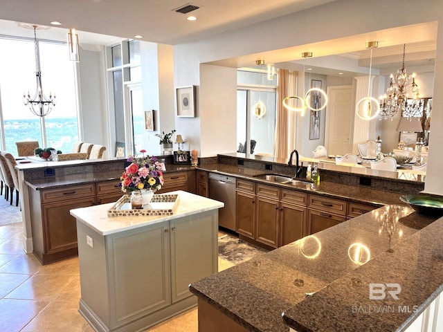 kitchen featuring a notable chandelier, sink, dark stone countertops, dishwasher, and kitchen peninsula