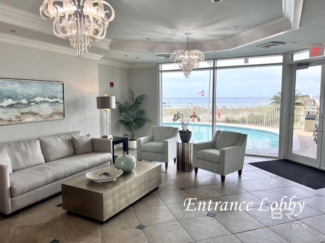 interior space with expansive windows, a chandelier, a water view, crown molding, and a raised ceiling