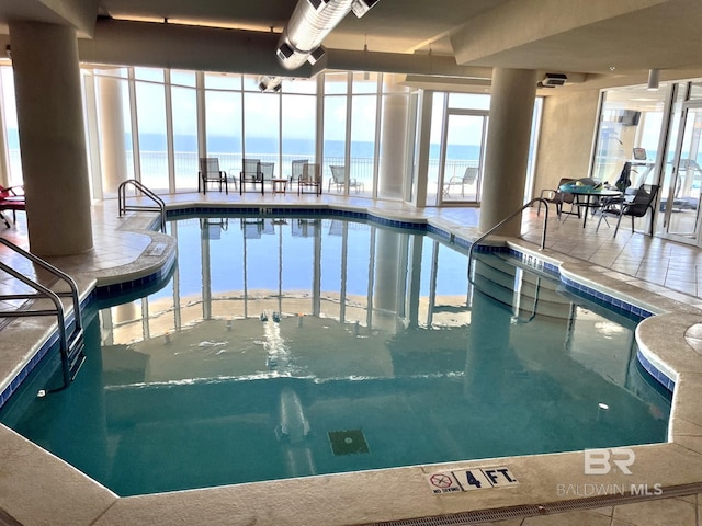 view of pool featuring a water view and a hot tub