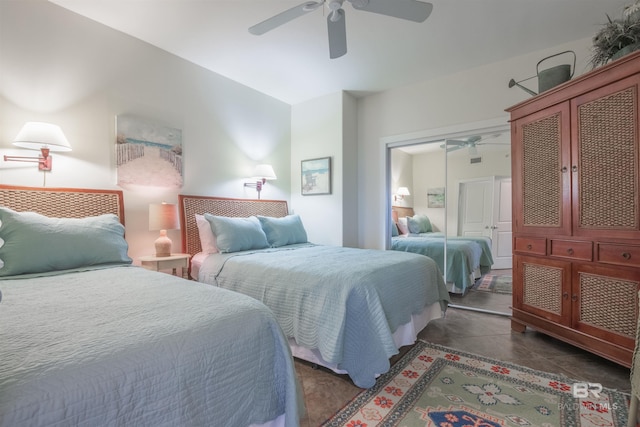 bedroom featuring dark tile patterned flooring, a closet, and ceiling fan