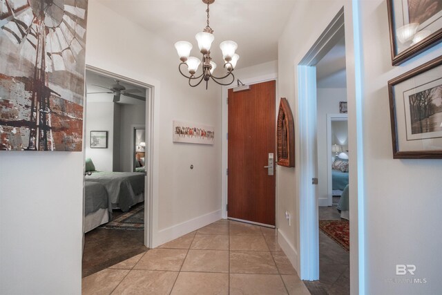 hallway featuring a notable chandelier and light tile patterned flooring