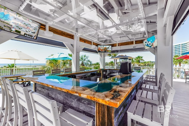 view of patio featuring a water view and exterior bar