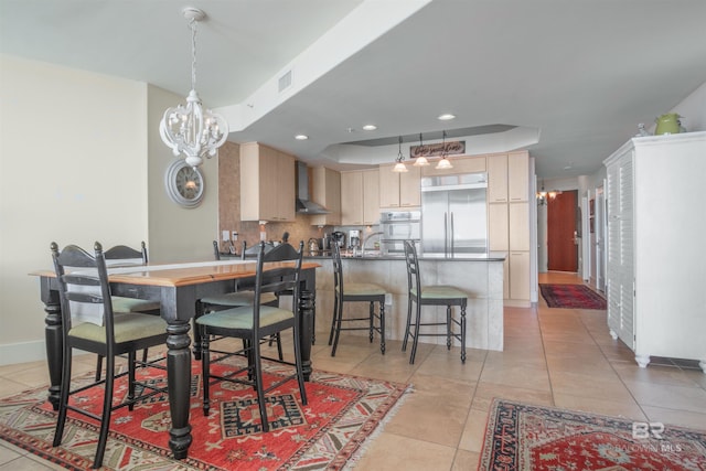 dining room featuring a notable chandelier, light tile patterned flooring, and a raised ceiling