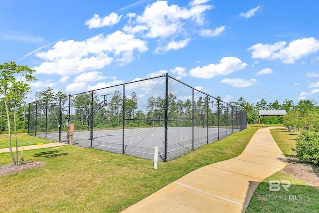 view of sport court featuring a yard and basketball hoop