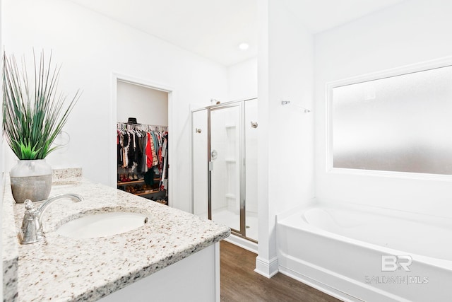 bathroom featuring vanity, separate shower and tub, and hardwood / wood-style floors