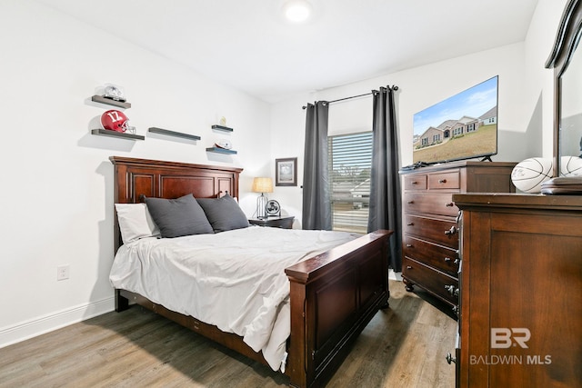 bedroom with dark hardwood / wood-style floors