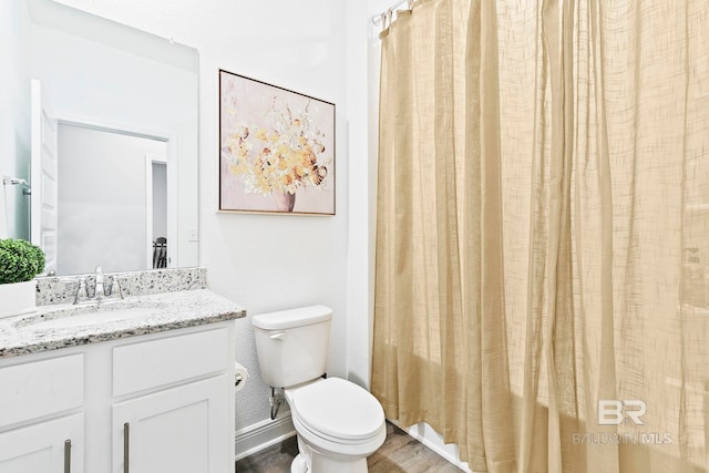 bathroom with hardwood / wood-style flooring, vanity, and toilet