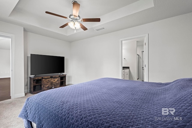 1311 Plymouth Dr, Foley, AL 36535 - carpeted bedroom with a tray ceiling, baseboards, ceiling fan, and ensuite bathroom