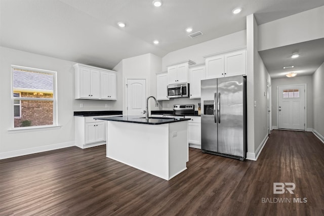 1311 Plymouth Dr, Foley, AL 36535 - kitchen featuring appliances with stainless steel finishes, dark countertops, lofted ceiling, dark wood-type flooring, and white cabinets