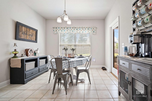 dining room featuring a notable chandelier, a wealth of natural light, and light tile patterned flooring