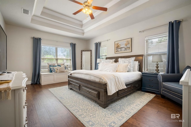 bedroom featuring ornamental molding, ceiling fan, a raised ceiling, and dark hardwood / wood-style flooring