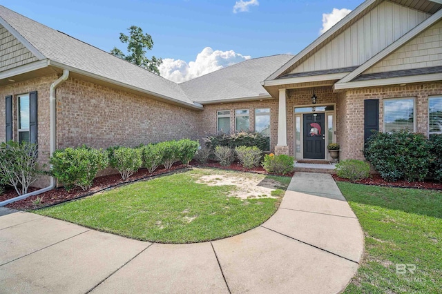 property entrance with a lawn