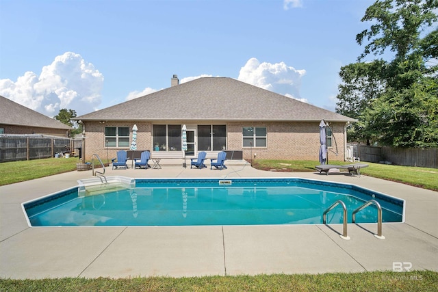 view of pool featuring a patio and a yard