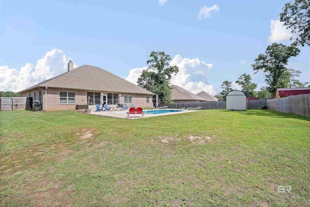 view of yard with a fenced in pool, a storage shed, and a patio area