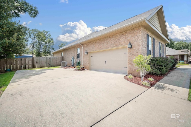 view of side of property with a garage and central air condition unit