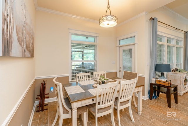 dining space featuring ornamental molding and light hardwood / wood-style flooring