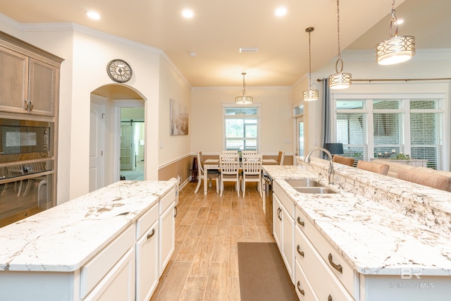 kitchen featuring hanging light fixtures, sink, black appliances, and a large island