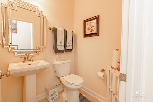 bathroom featuring sink, toilet, and tile floors