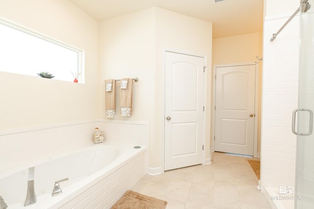 bathroom featuring tile floors and a relaxing tiled bath