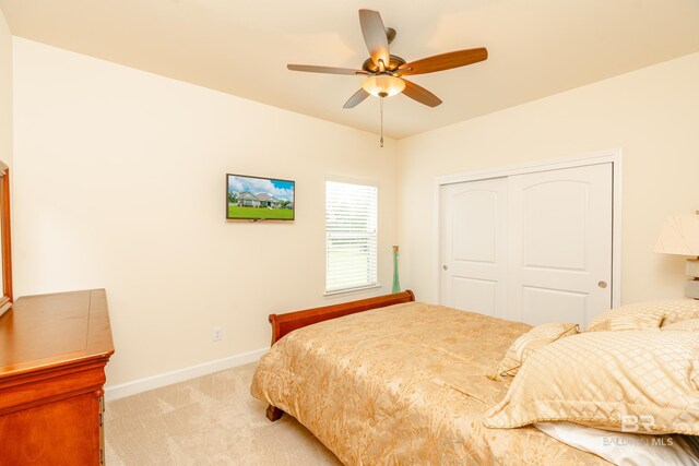 carpeted bedroom featuring a closet and ceiling fan