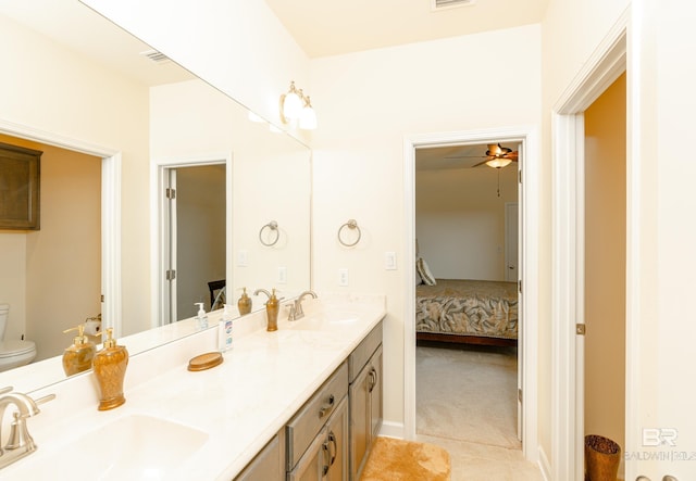 bathroom featuring tile flooring, double sink vanity, toilet, and ceiling fan