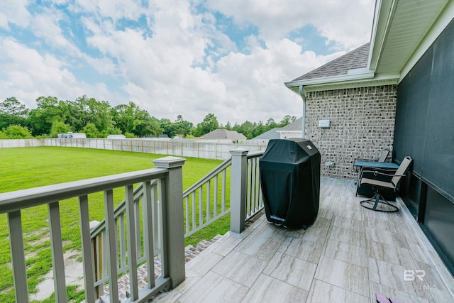 wooden deck featuring a lawn and grilling area