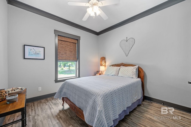 bedroom featuring ceiling fan, ornamental molding, and dark wood-type flooring