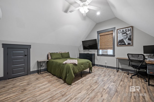 bedroom with ceiling fan, vaulted ceiling, and hardwood / wood-style floors