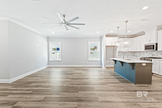 kitchen featuring an island with sink, light hardwood / wood-style floors, and decorative backsplash