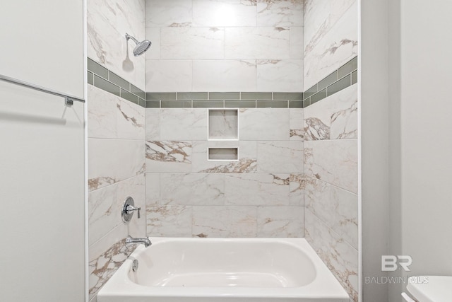 bathroom featuring toilet and tiled shower / bath combo