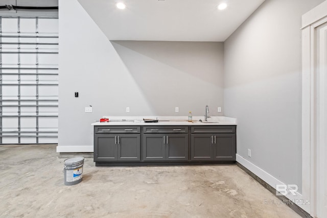 bar with gray cabinetry and sink