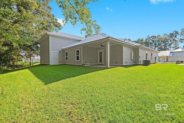 rear view of property featuring ceiling fan, cooling unit, a patio, and a yard