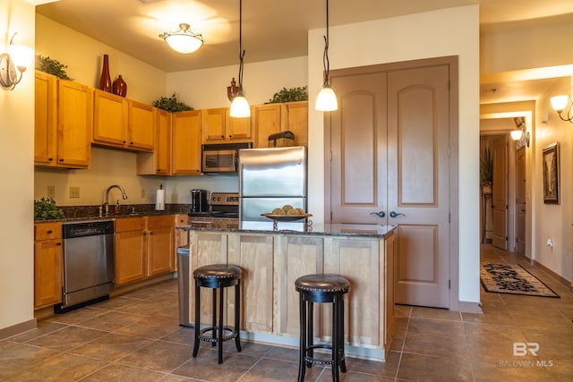 1430 Regency Rd Unit J302, Gulf Shores, AL 36542 - kitchen featuring stainless steel appliances, a center island, a kitchen breakfast bar, decorative light fixtures, and dark tile patterned floors