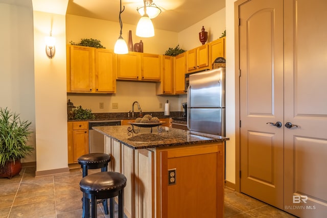 1430 Regency Rd Unit J302, Gulf Shores, AL 36542 - kitchen featuring a center island, a breakfast bar area, pendant lighting, baseboards, and dark stone countertops