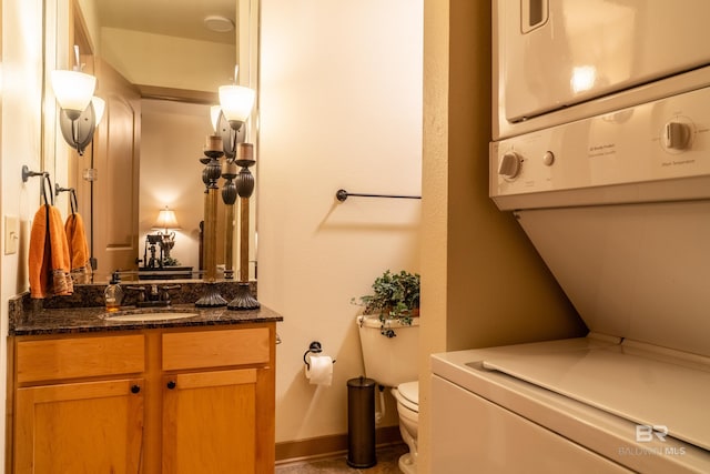 1430 Regency Rd Unit J302, Gulf Shores, AL 36542 - bathroom featuring stacked washer / drying machine, toilet, vanity, and baseboards