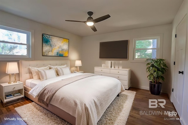 bedroom with multiple windows, ceiling fan, and dark hardwood / wood-style floors