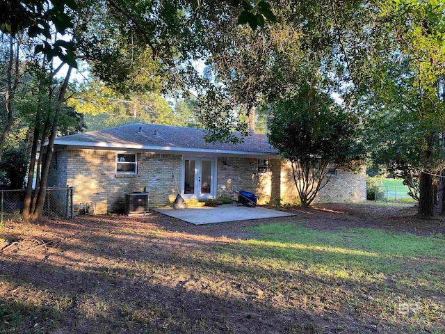 rear view of property with french doors, central AC unit, a patio, and a yard