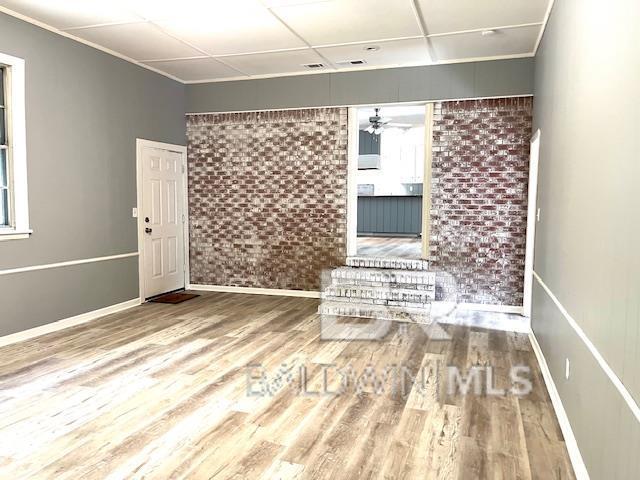 spare room with hardwood / wood-style flooring and a drop ceiling