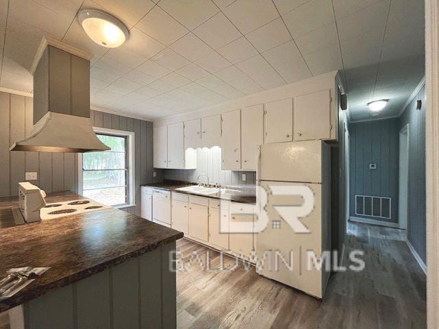 kitchen featuring sink, white appliances, white cabinets, and island exhaust hood