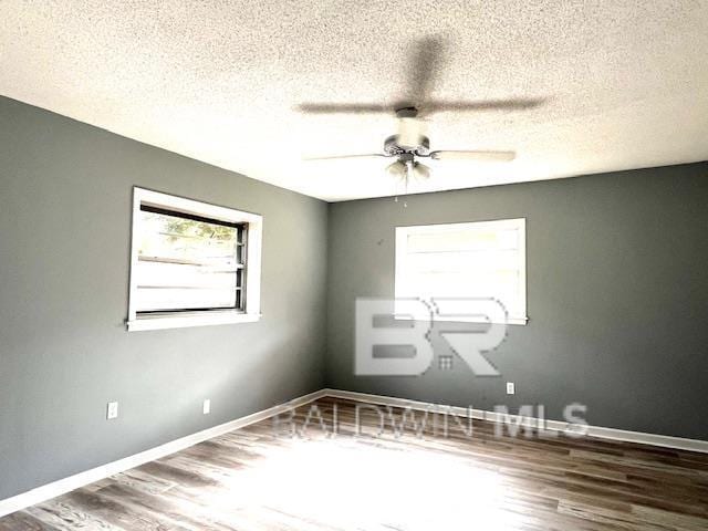 unfurnished room with hardwood / wood-style flooring, ceiling fan, and a textured ceiling