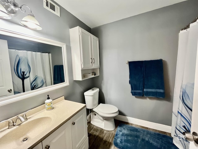 bathroom with vanity, toilet, and hardwood / wood-style floors