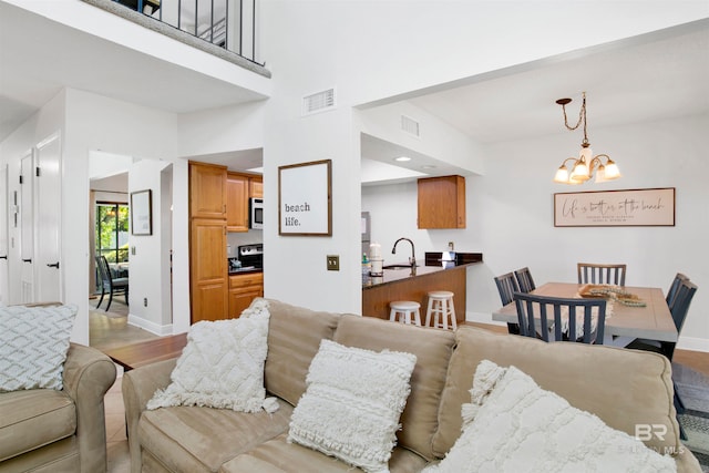 living room featuring light hardwood / wood-style flooring, a chandelier, and sink