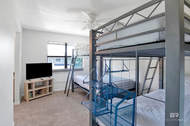 carpeted bedroom featuring ceiling fan and a textured ceiling