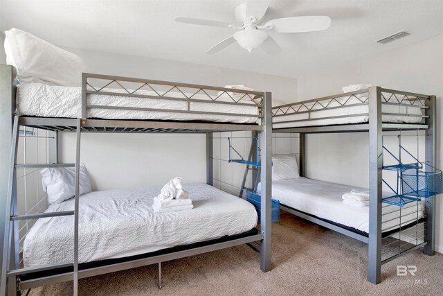 bedroom with ceiling fan, carpet floors, and multiple windows